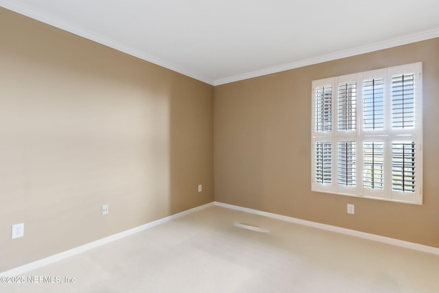 empty room featuring baseboards, crown molding, and carpet flooring