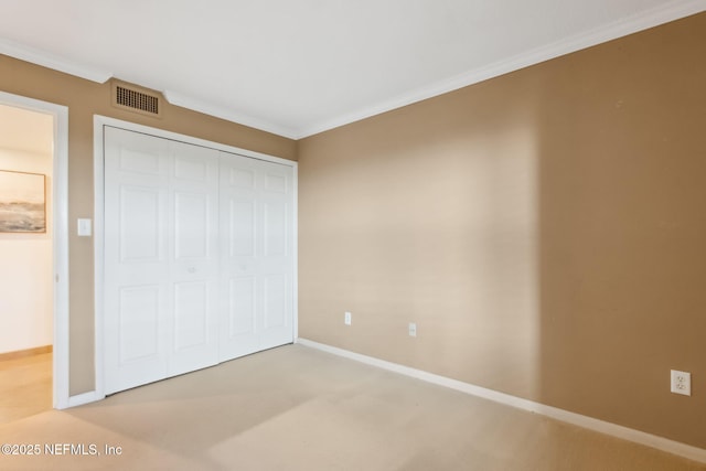 unfurnished bedroom with a closet, visible vents, crown molding, and baseboards