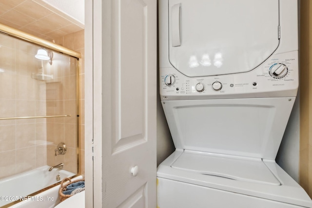 washroom featuring stacked washer and dryer and laundry area