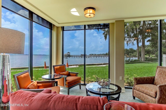 sunroom / solarium featuring a water view and a healthy amount of sunlight