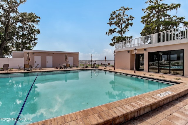 community pool featuring fence and a patio