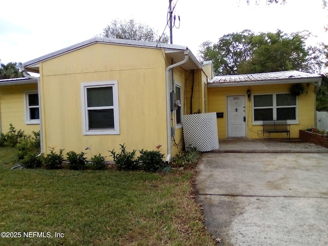 view of home's exterior featuring a yard and concrete driveway
