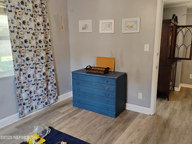 bedroom featuring baseboards and wood finished floors