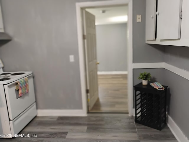 kitchen featuring wood finished floors, baseboards, and electric stove