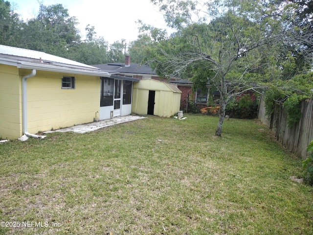 view of yard with a shed, a fenced backyard, and an outdoor structure