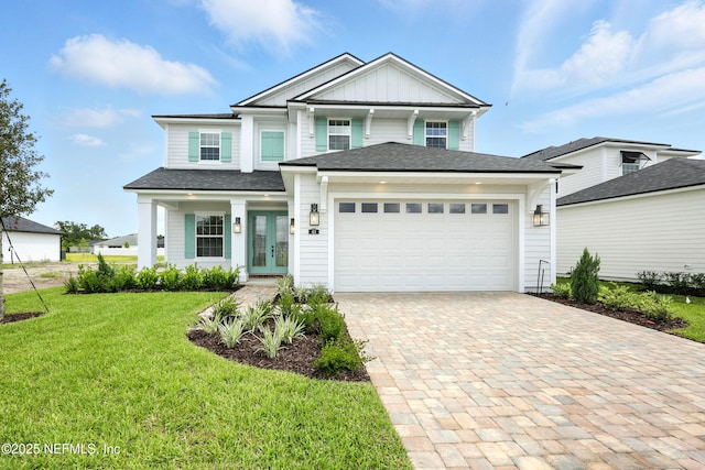 41 Iris Creek Dr, Saint Augustine, FL 32092 - view of front facade with french doors, a front lawn, board and batten siding, a garage, and decorative driveway
