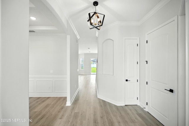 41 Iris Creek Dr, Saint Augustine, FL 32092 - hallway with light wood-style flooring, a chandelier, crown molding, and wainscoting