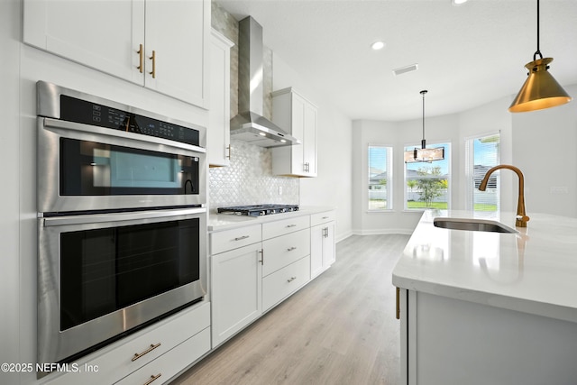 41 Iris Creek Dr, Saint Augustine, FL 32092 - kitchen featuring stainless steel appliances, wall chimney exhaust hood, light wood finished floors, tasteful backsplash, and recessed lighting