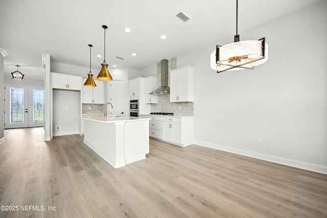41 Iris Creek Dr, Saint Augustine, FL 32092 - kitchen featuring wall chimney exhaust hood, stovetop, recessed lighting, light wood-style flooring, and backsplash