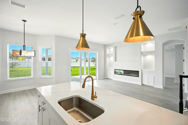 41 Iris Creek Dr, Saint Augustine, FL 32092 - kitchen with light wood-style floors, open floor plan, decorative light fixtures, and light stone counters