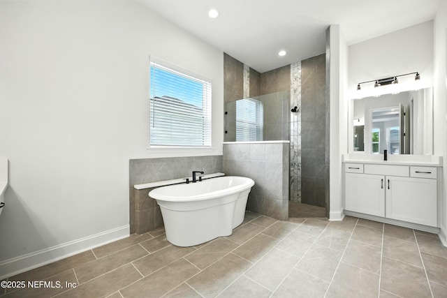 41 Iris Creek Dr, Saint Augustine, FL 32092 - bathroom featuring vanity, a walk in shower, a freestanding bath, tile patterned flooring, and recessed lighting