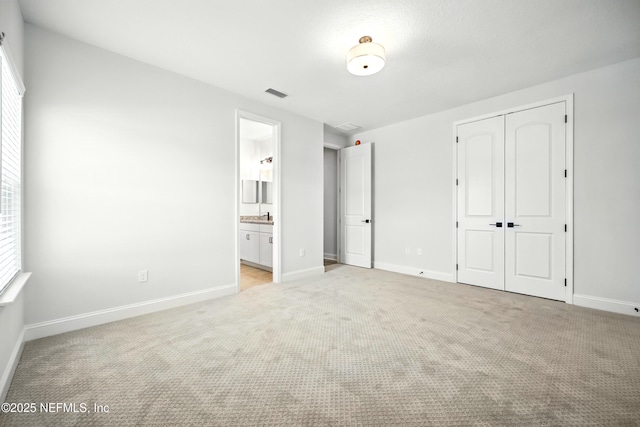 41 Iris Creek Dr, Saint Augustine, FL 32092 - unfurnished bedroom featuring light colored carpet, a closet, and ensuite bath