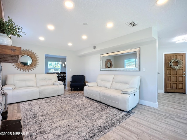 living area featuring wood finished floors, visible vents, and baseboards