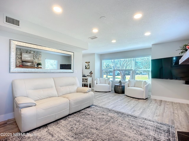 living room featuring visible vents and wood finished floors