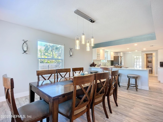 dining area with baseboards, recessed lighting, a wealth of natural light, and light wood-style floors