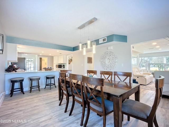 dining space with light wood-type flooring, baseboards, visible vents, and recessed lighting