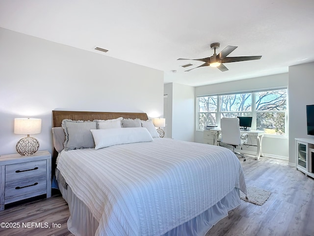 bedroom featuring visible vents, light wood finished floors, a ceiling fan, and baseboards