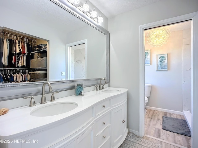 full bath with wood finished floors, a sink, toilet, and double vanity