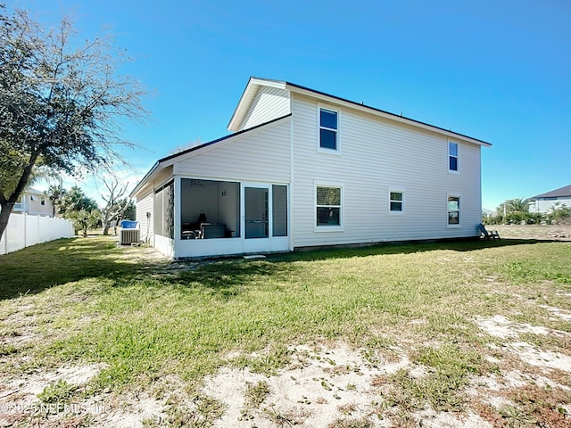 rear view of house with a yard, fence, a sunroom, and central air condition unit