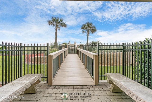 view of home's community with a yard and fence