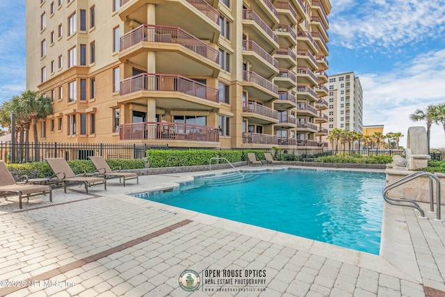 community pool featuring a patio and fence