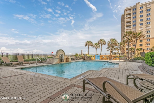 pool featuring fence and a patio