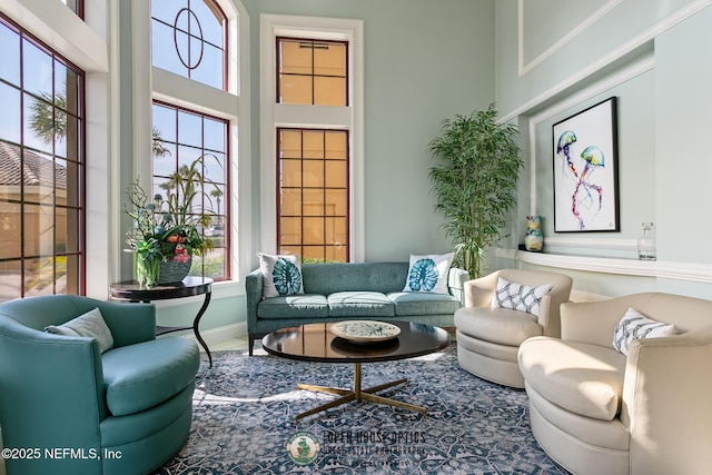 living room with a towering ceiling and baseboards