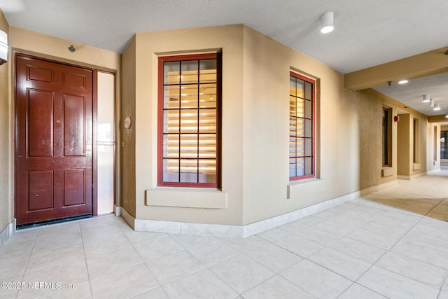 interior space featuring light tile patterned floors, recessed lighting, and baseboards