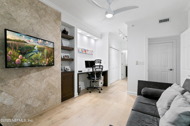 home office with visible vents, built in features, light wood-type flooring, built in study area, and crown molding