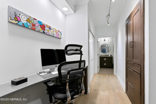 office featuring light wood finished floors, crown molding, and rail lighting