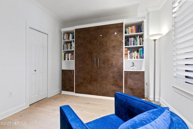 living area with crown molding, baseboards, and wood finished floors