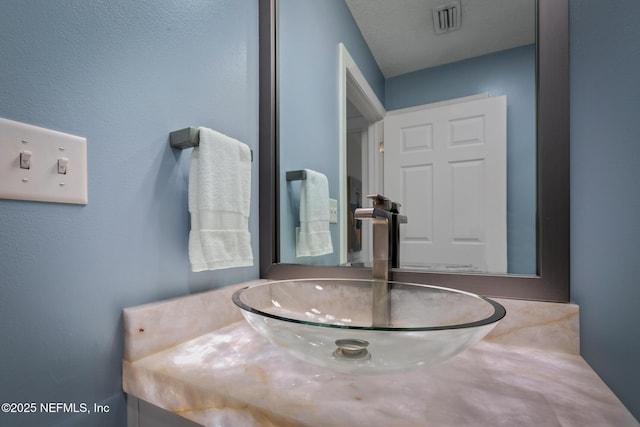 bathroom featuring visible vents and a sink