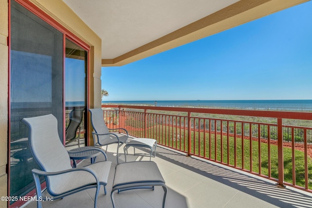 balcony featuring a beach view and a water view