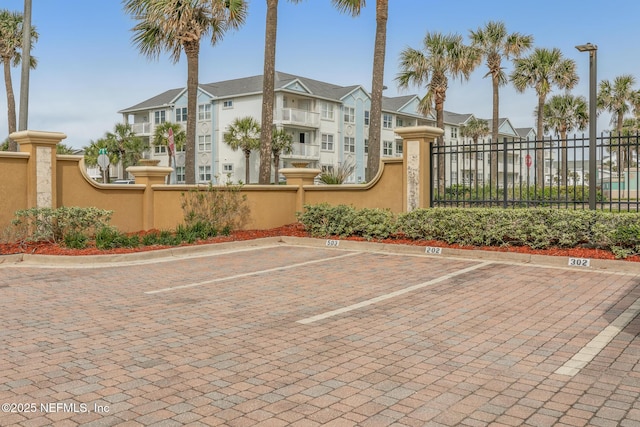 uncovered parking lot with a residential view and fence