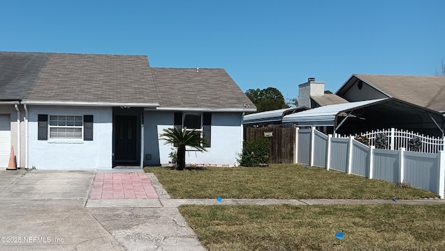 view of front facade featuring a shingled roof, fence, a front lawn, and stucco siding