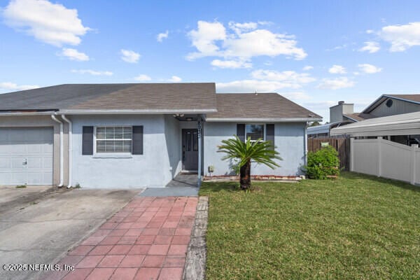 single story home with a garage, fence, concrete driveway, stucco siding, and a front yard