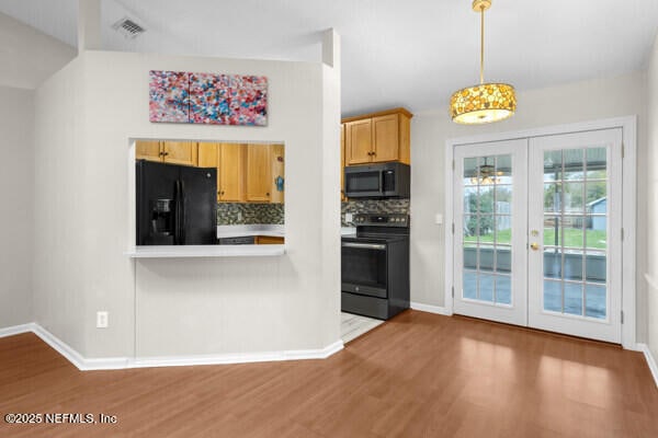 kitchen with french doors, visible vents, decorative backsplash, wood finished floors, and black appliances