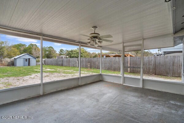 unfurnished sunroom featuring ceiling fan