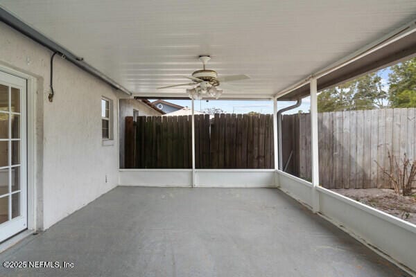 unfurnished sunroom with a ceiling fan