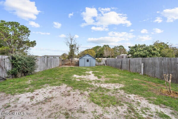 view of yard with a shed, an outdoor structure, and a fenced backyard