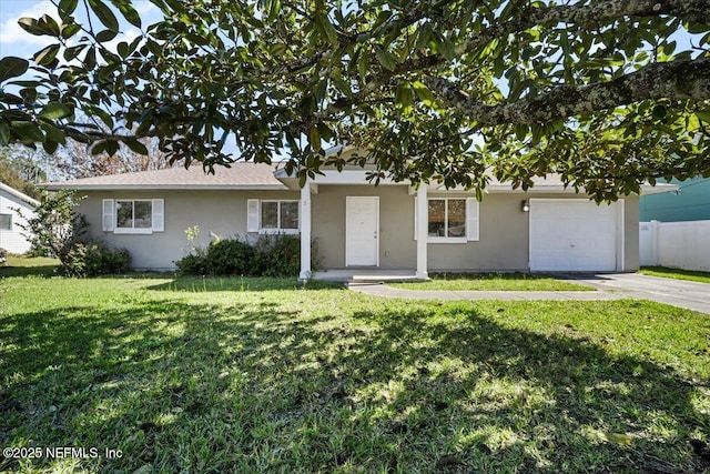 single story home with an attached garage, concrete driveway, a front yard, and stucco siding