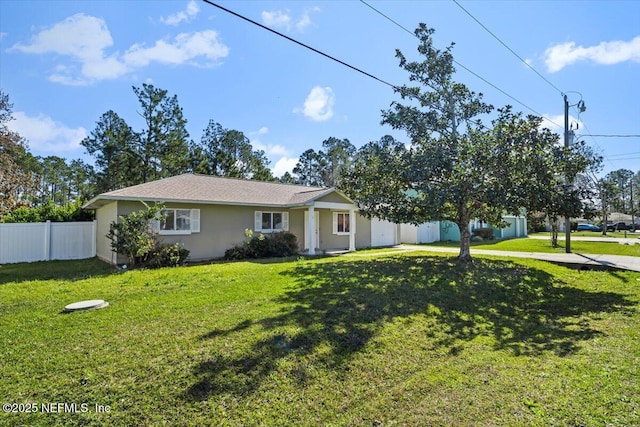 ranch-style home featuring a front yard, fence, and stucco siding