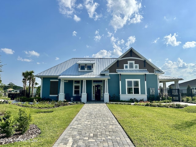 craftsman-style home featuring metal roof, a front lawn, a standing seam roof, and fence