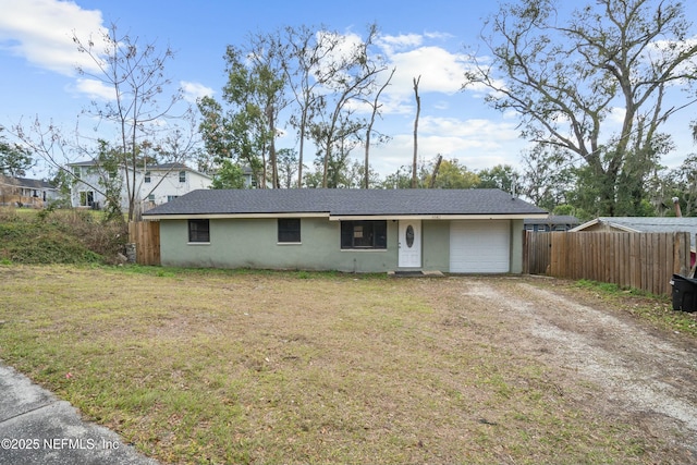 ranch-style house with a garage, a front lawn, fence, and dirt driveway