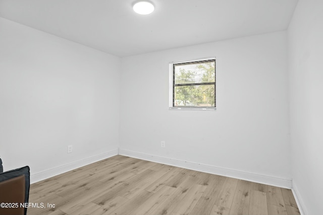 empty room with baseboards and light wood finished floors