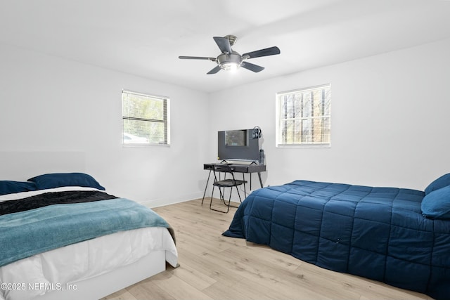 bedroom with ceiling fan, baseboards, and wood finished floors