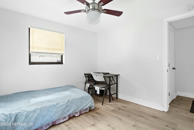 bedroom with ceiling fan, baseboards, and wood finished floors