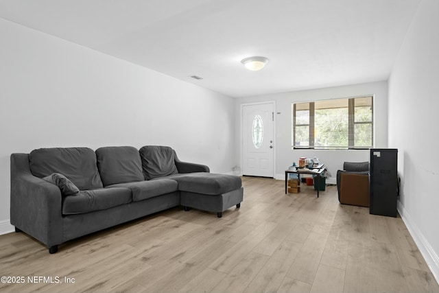 living area with light wood-style flooring and baseboards