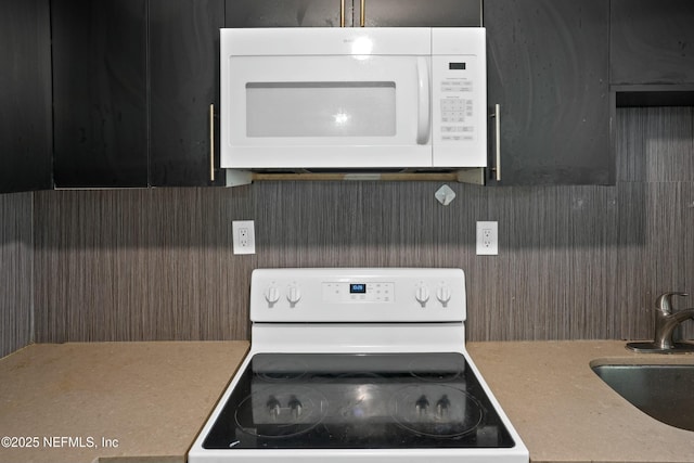 kitchen with light countertops, white appliances, and a sink