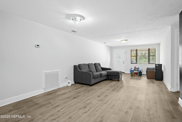 living area with visible vents, baseboards, and wood finished floors